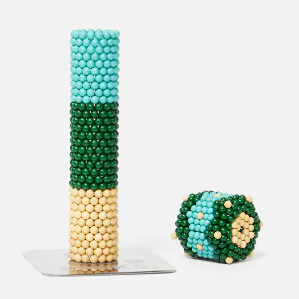 Bilder von bunten Perlenkugeln in einem Turm und einem geformten Würfel.